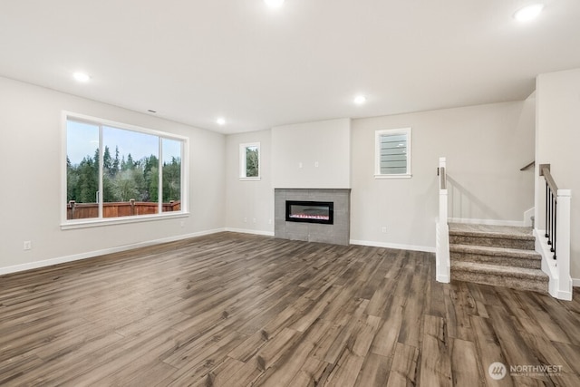 unfurnished living room featuring a tile fireplace and hardwood / wood-style floors