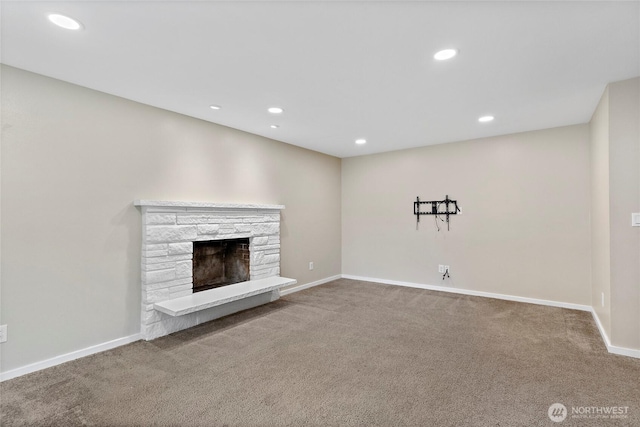 unfurnished living room featuring a stone fireplace and carpet floors