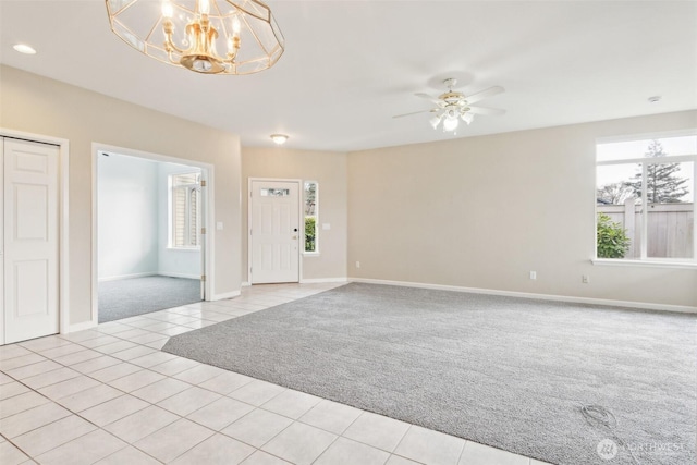 interior space with light carpet and ceiling fan with notable chandelier