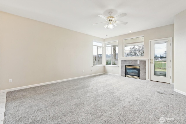 unfurnished living room with ceiling fan, carpet, and a tile fireplace