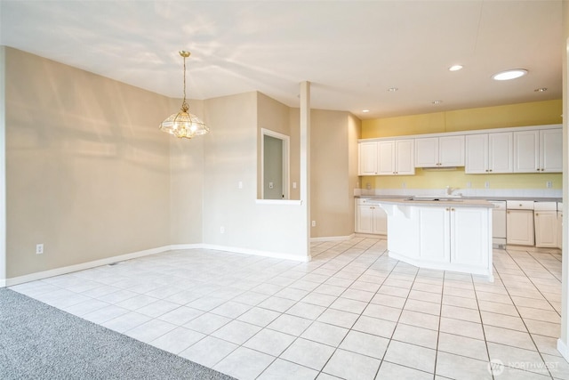 kitchen with decorative light fixtures, a center island, light tile patterned floors, and white cabinets