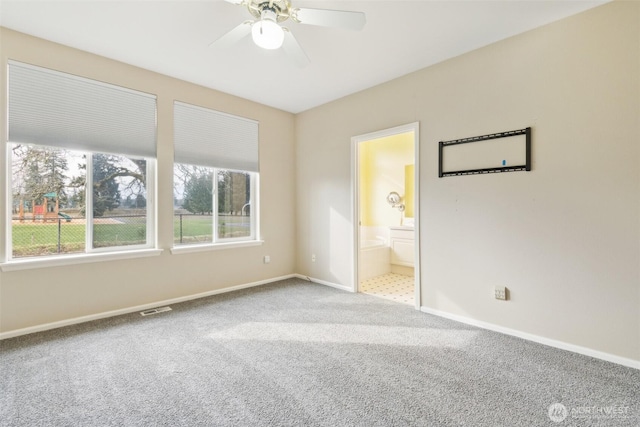 unfurnished bedroom with ceiling fan, carpet flooring, and ensuite bath