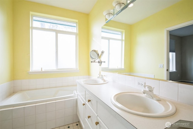 bathroom featuring vanity and a relaxing tiled tub