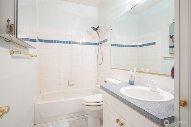 full bathroom featuring tile patterned flooring, tiled shower / bath, vanity, and toilet