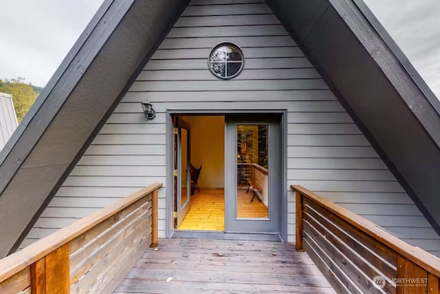 view of exterior entry with a wooden deck