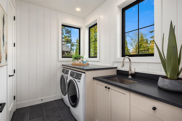 clothes washing area featuring cabinets, sink, and independent washer and dryer