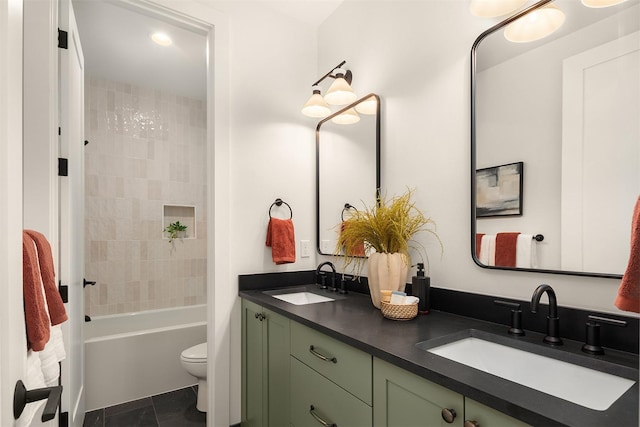 full bathroom featuring tile patterned flooring, vanity, tiled shower / bath, and toilet