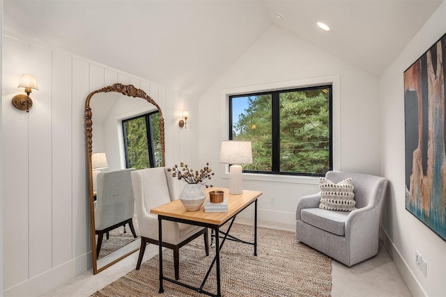 living area with lofted ceiling, plenty of natural light, and light colored carpet