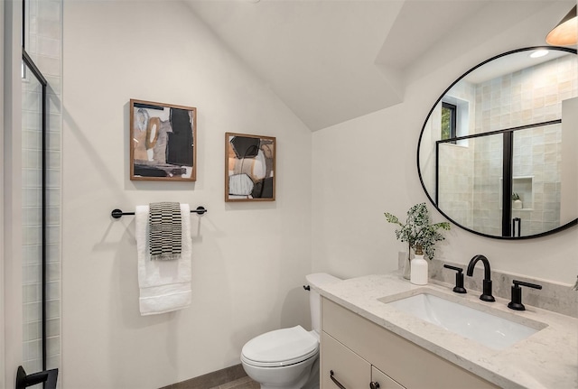 bathroom featuring vanity, a shower with shower door, toilet, and vaulted ceiling