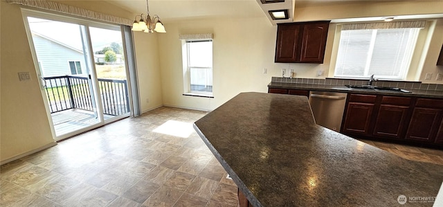 kitchen featuring dark brown cabinetry, sink, an inviting chandelier, stainless steel dishwasher, and pendant lighting