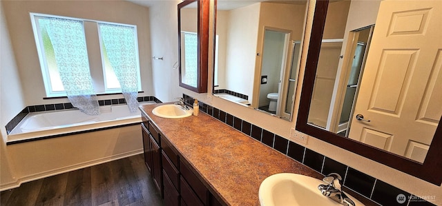 full bathroom featuring wood-type flooring, separate shower and tub, vanity, and toilet