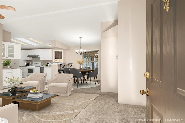 living room with light colored carpet, a chandelier, and vaulted ceiling