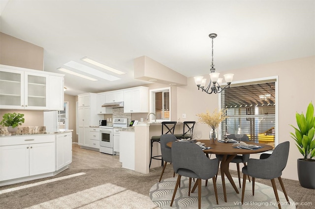 carpeted dining room featuring lofted ceiling, sink, and a notable chandelier