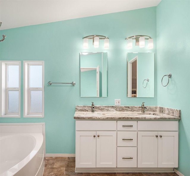 bathroom featuring a tub to relax in and vanity