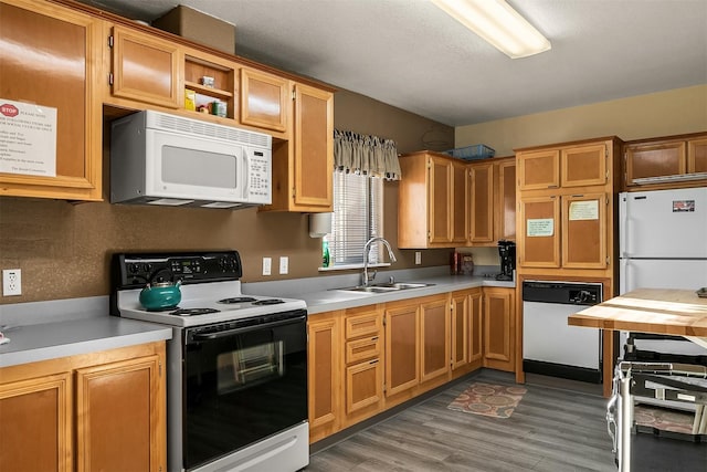 kitchen with white appliances, dark hardwood / wood-style floors, sink, and a textured ceiling