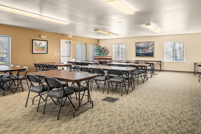 dining space featuring carpet floors and a textured ceiling