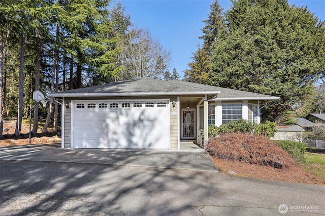 ranch-style house with an attached garage and aphalt driveway