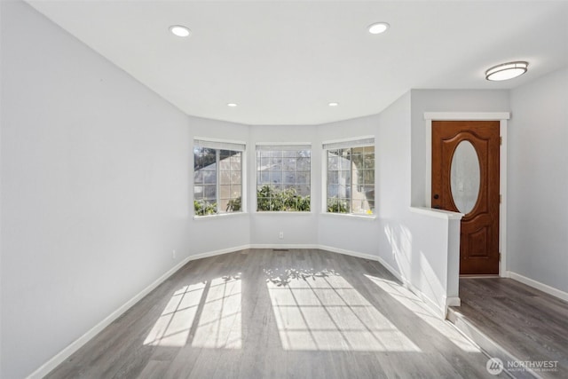 interior space featuring recessed lighting, baseboards, and wood finished floors