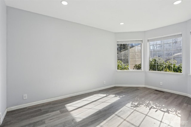 spare room featuring recessed lighting, visible vents, baseboards, and wood finished floors