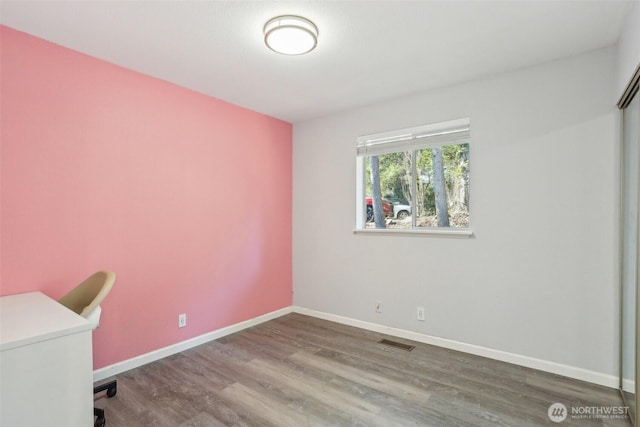 unfurnished office featuring visible vents, baseboards, and wood finished floors