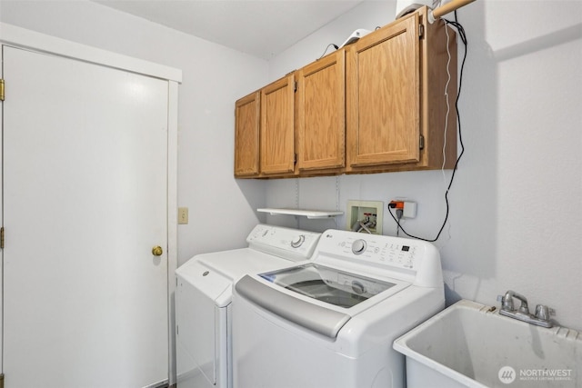 laundry room with cabinet space, a sink, and separate washer and dryer