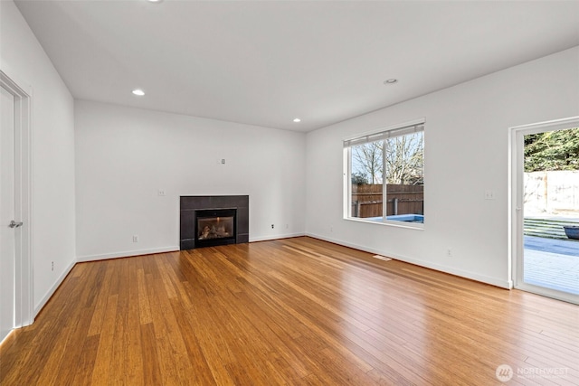 unfurnished living room featuring hardwood / wood-style floors and plenty of natural light