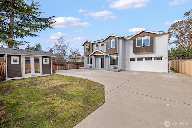 view of front of house featuring a garage, an outbuilding, and a front yard