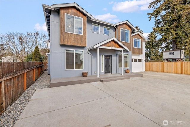 back of house with a garage and a patio area