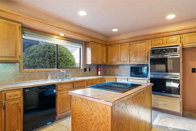 kitchen with black appliances, light countertops, a sink, and a center island