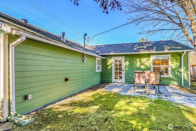 rear view of property with a yard and a patio area