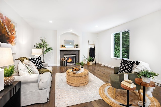 living room featuring hardwood / wood-style flooring and a tile fireplace