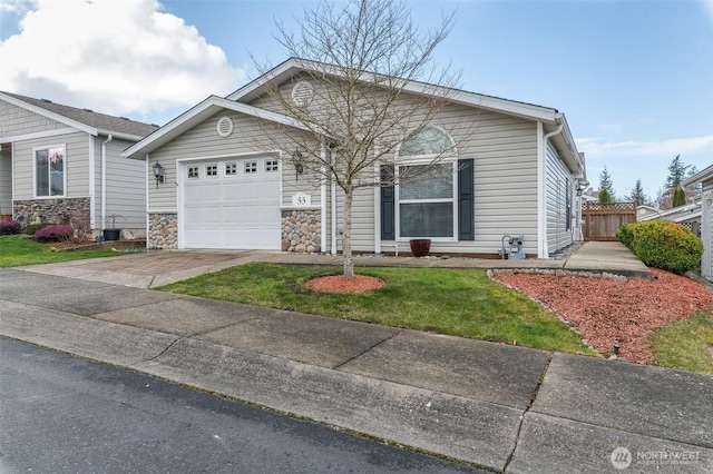 view of front facade with a garage, concrete driveway, stone siding, and fence