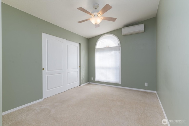 unfurnished bedroom featuring carpet, ceiling fan, a wall unit AC, and baseboards