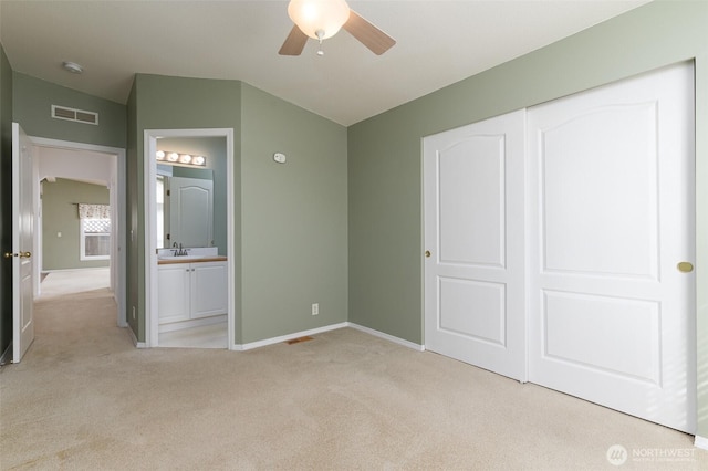 unfurnished bedroom with light colored carpet, a sink, visible vents, baseboards, and a closet