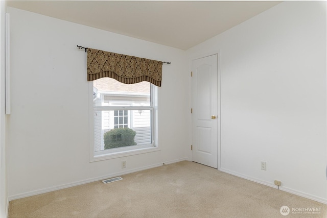 carpeted spare room with baseboards and visible vents