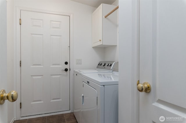 clothes washing area featuring washing machine and dryer, cabinet space, and dark tile patterned flooring