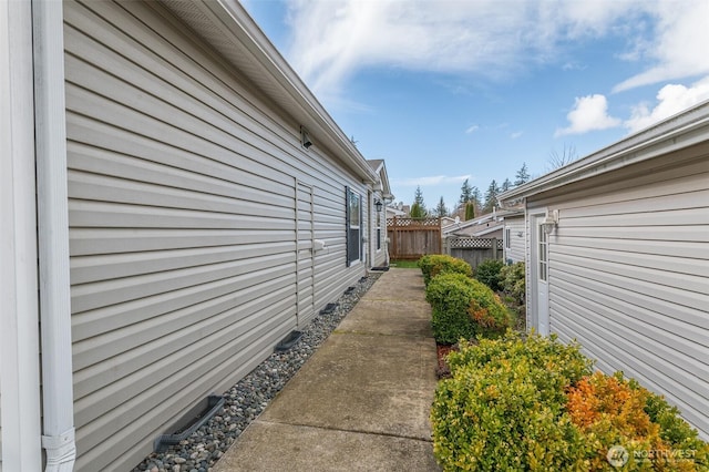 view of side of home featuring fence