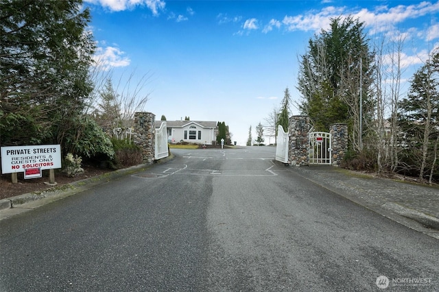 view of street with curbs and a gate