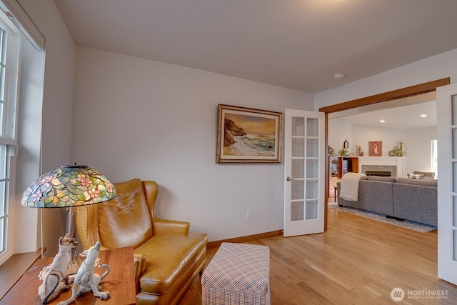 living area with light hardwood / wood-style floors and french doors