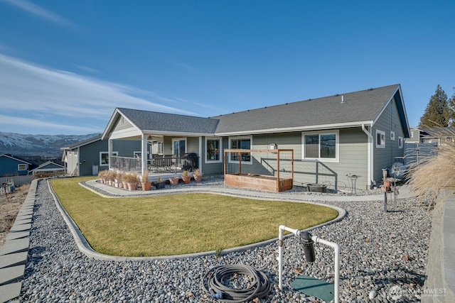 rear view of property featuring a mountain view and a yard