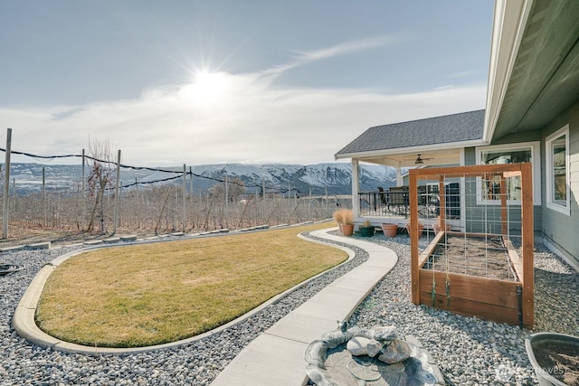 view of yard with ceiling fan and a mountain view