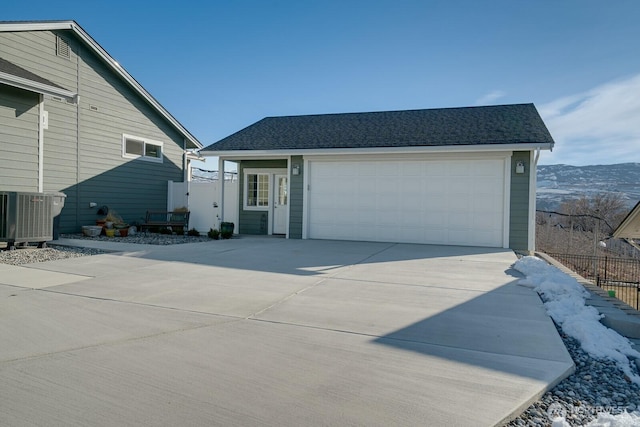 view of front of house featuring cooling unit, a mountain view, and a garage