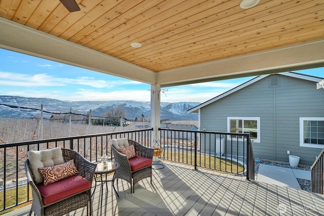 wooden terrace featuring a mountain view and ceiling fan