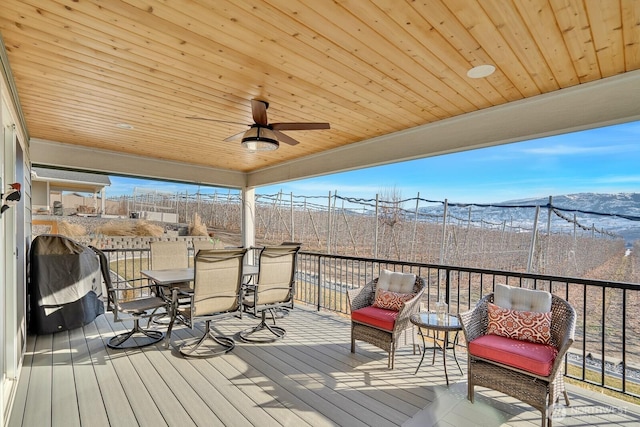 wooden terrace with grilling area and ceiling fan