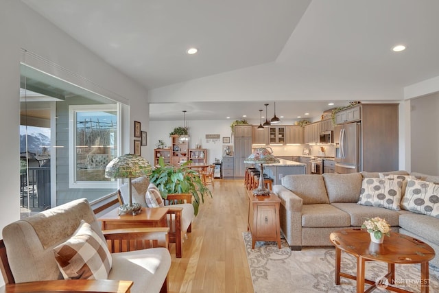 living room with vaulted ceiling and light hardwood / wood-style floors