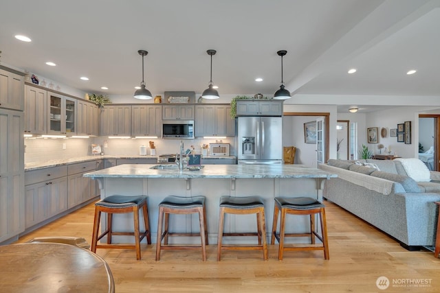 kitchen with pendant lighting, stainless steel appliances, a breakfast bar, and a spacious island