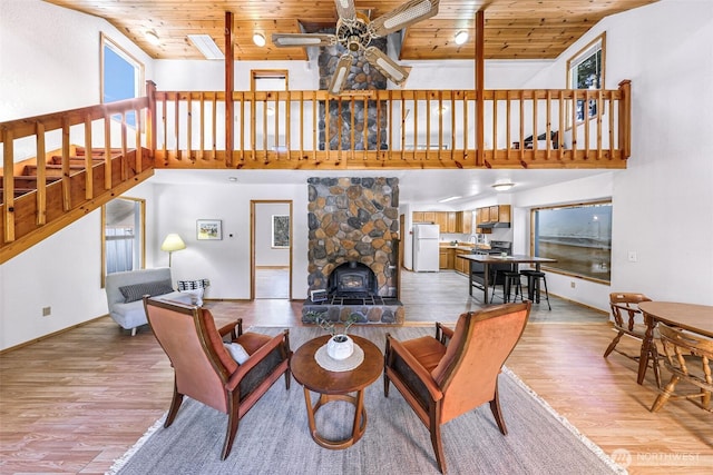 living area featuring light wood-style floors, wood ceiling, stairs, and ceiling fan