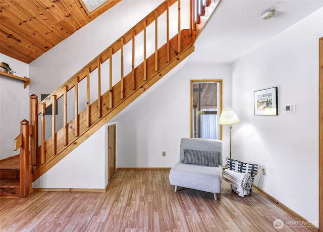 living area with light wood finished floors, stairway, and baseboards