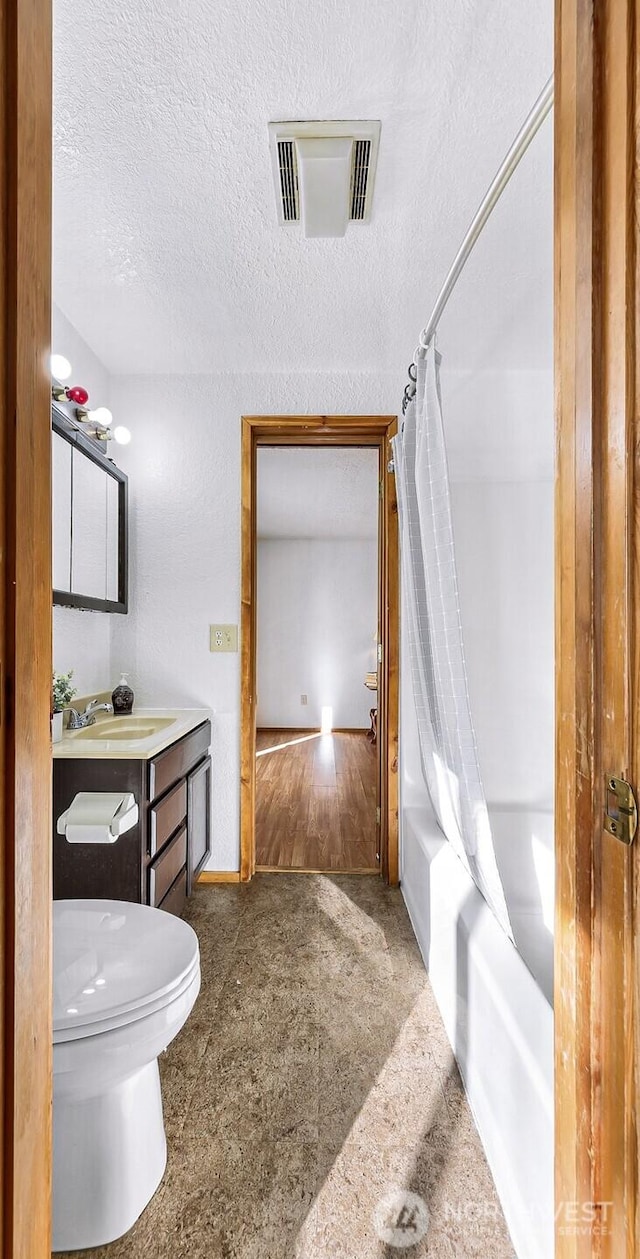 full bathroom with a textured ceiling, toilet, a sink, visible vents, and shower / bath combo