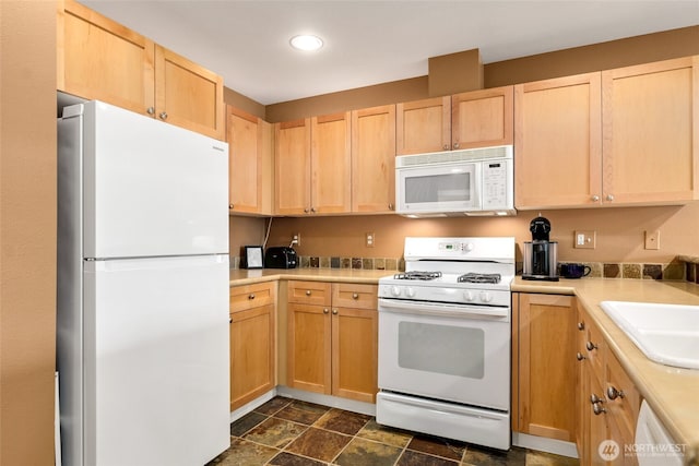 kitchen with white appliances, sink, and light brown cabinets